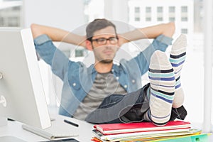 Relaxed casual young man with legs on desk