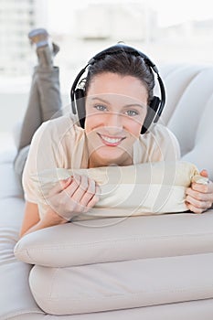 Relaxed casual young woman enjoying music on sofa