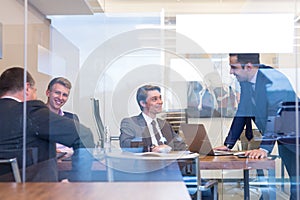 Relaxed cheerful business people sitting and talking at corporate meeting.