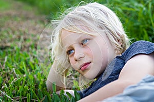 Relaxed child outdoors lying on grass