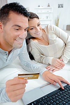 relaxed couple making online purchase with credit card