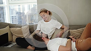 Relaxed couple relaxing on sofa together enjoying their relationships. Blonde woman looking on side while man is lying