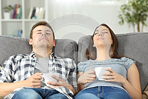 Relaxed couple resting at home on a couch photo