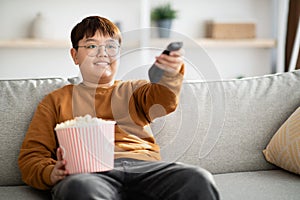 Relaxed chinese kid watching TV at home