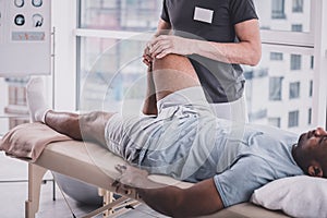 Relaxed dark-skinned man visiting his rehabilitation massage photo