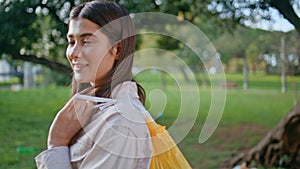 Relaxed eco volunteer holding waste bag in park. Portrait woman after cleanup