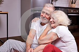 relaxed elderly man and woman sit taking a break after yoga