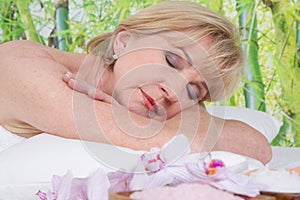 Relaxed elderly woman in spa with closed eyes