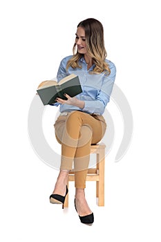 Relaxed fascinated businesswoman reads while sitting