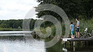 Relaxed father and son fishing at freshwater pond