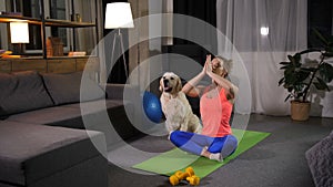 Relaxed female with dog practicing yoga lotus pose