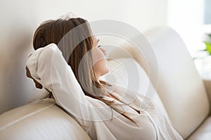 Relaxed female lying on sofa thinking or dreaming