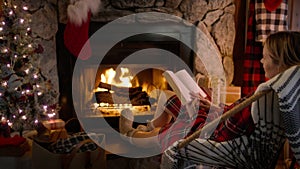 Relaxed female sitting in chair and enjoying her winter holiday weekend in cabin