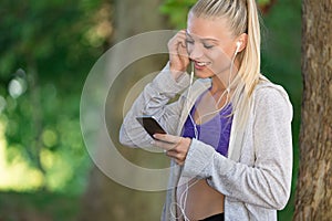 Relaxed fitness woman texting sms on smartphone during a workout break.