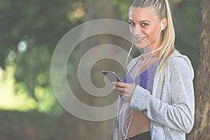 Relaxed fitness woman texting sms on smartphone during a workout break.