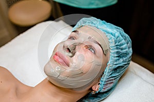 Relaxed girl having pore cleaning procedure in parlor.