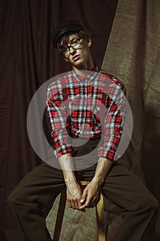 Relaxed handsome young guy in checkered shirt and glasses