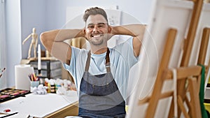 A relaxed, handsome young man in a studio setting, showcasing a creative atmosphere