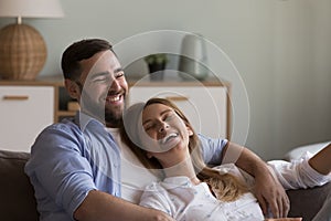 Relaxed happy dating couple in love resting on cozy couch