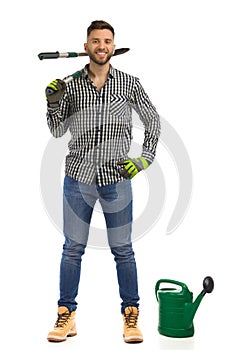 Relaxed happy gardener is standing with big secateur. Front view. Full length isolated on white