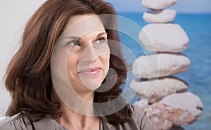 Relaxed and happy older woman portrait with a stag of blue stone