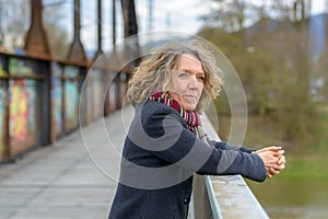 Relaxed happy woman leaning on a bridge parapet