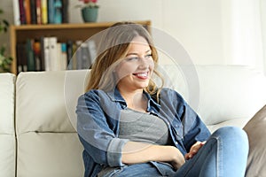 Relaxed happy woman sitting on a couch at home