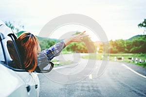 Relaxed happy woman traveler on summer roadtrip vacation on hatchback ca