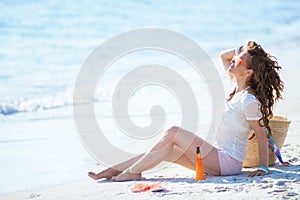 Relaxed healthy middle age woman sitting on seacoast