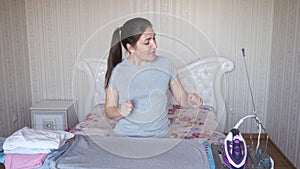 Relaxed housewife dances and sings during ironing at home
