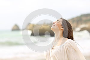 Relaxed lady breathing fresh air on the beach