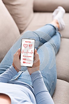 Relaxed lady checking new health mobile app on smartphone