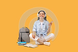 Relaxed lady student with headphones enjoying music on her smartphone during study break