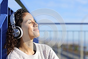 Relaxed latina girl listening to music outdoors