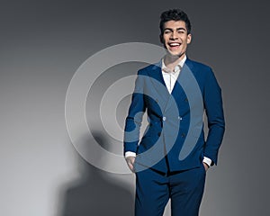 relaxed male model laughing with hands in pockets