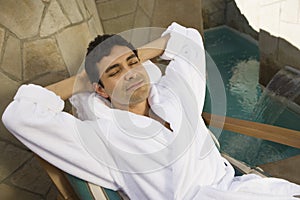 Relaxed Man In Bathrobe Sitting On Chair photo