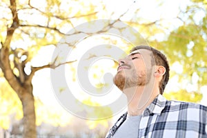 Relaxed man is breathing fresh air in a park