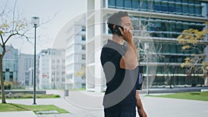Relaxed man calling mobile phone near office. Casual guy having business call