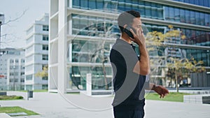 Relaxed man calling mobile phone near office. Casual guy having business call