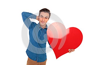 Relaxed man holding big red heart with hand behind neck