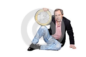Relaxed man holding an euro coin