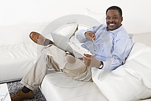 Relaxed Man With Laptop Sitting On Sofa