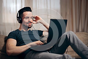 Relaxed Man Listening to Music on His Laptop at Home