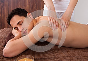 Relaxed Man Receiving Shoulder Massage In Spa