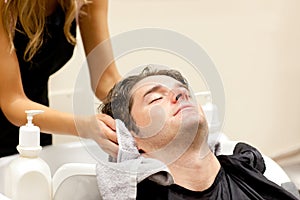 Relaxed man shampooed by his female hairdresser