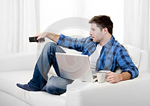 Relaxed man using Computer at home switching tv on