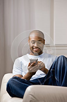 Relaxed man using electronic organizer