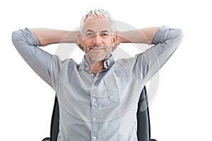 Relaxed mature businessman with hands behind head