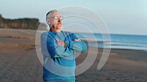Relaxed mature man standing at sea beach coast contemplating sunset enjoy freedom retirement outdoor