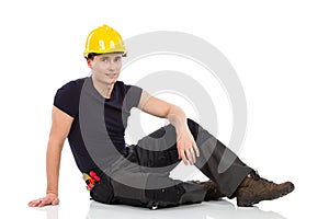 Relaxed mechanic sitting on a floor